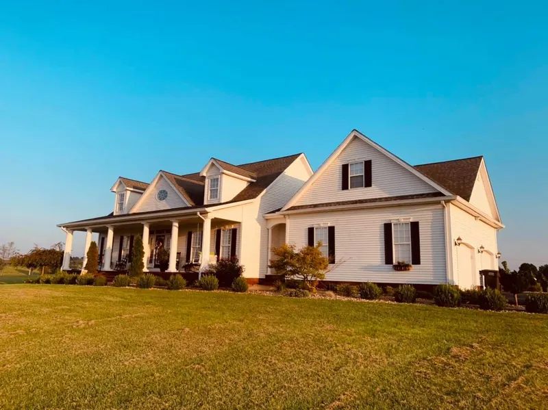 White farmhouse with a wraparound porch