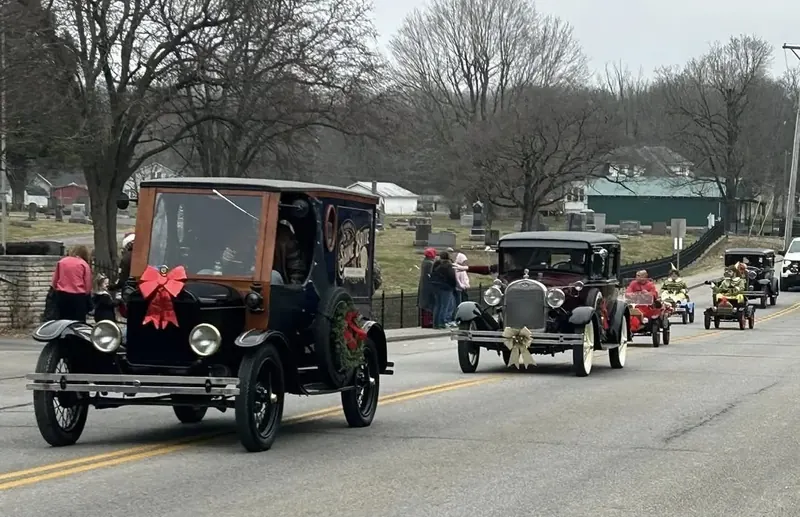Model T leading a line of classic cars in a parade